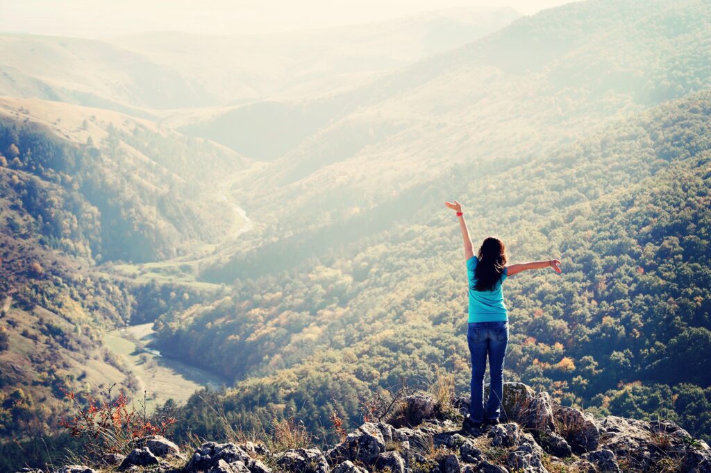 Woman rejoicing on top of the mountain